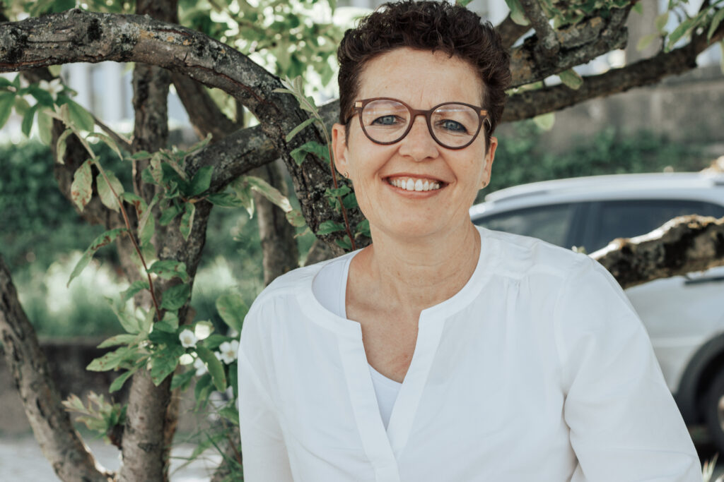 Silke Lemhöfer lächelt vor einem alten Baum