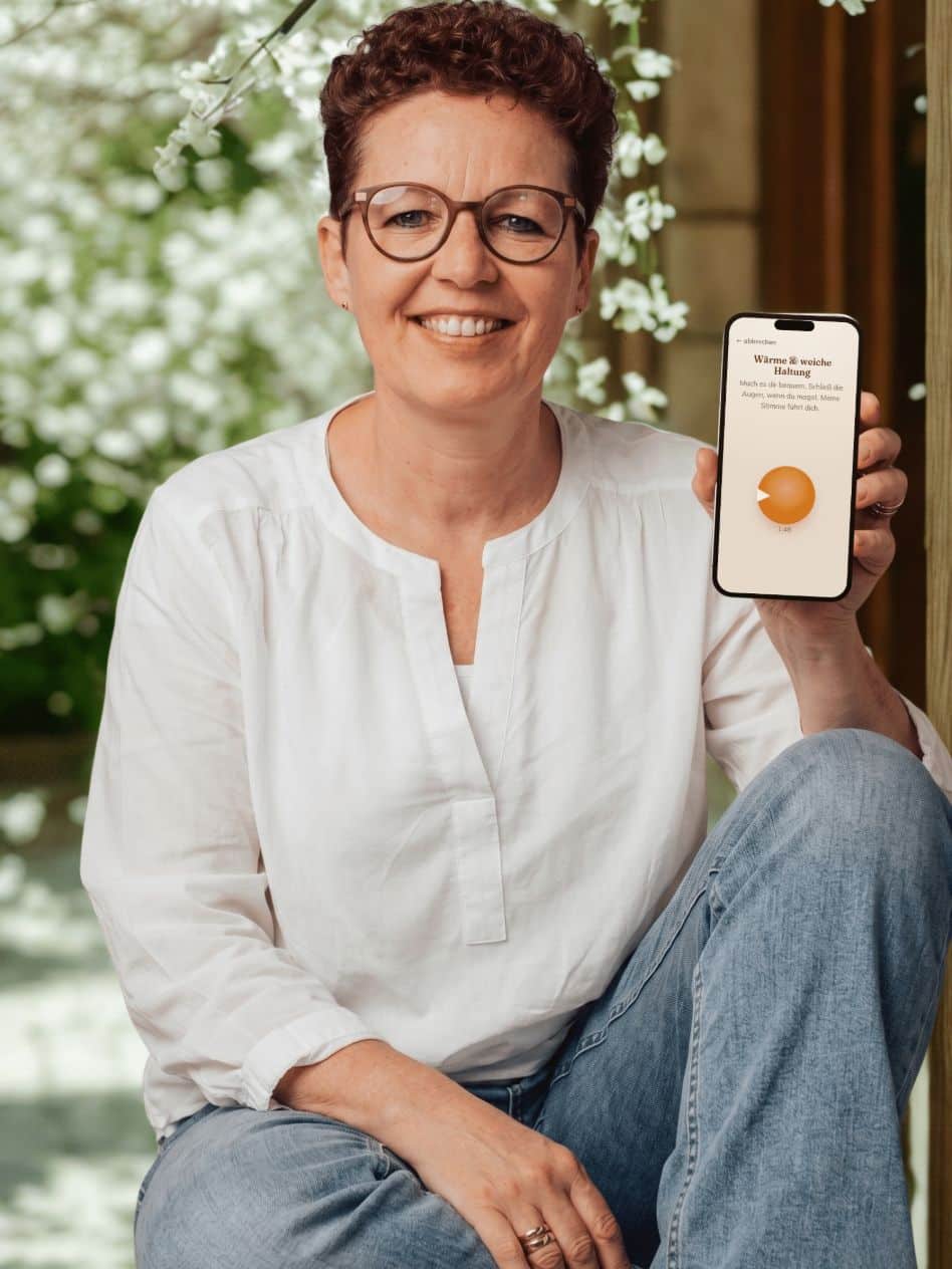 Silke Lemhöfer hält die Erste-Hilfe-Tasche-App auf dem Smartphone