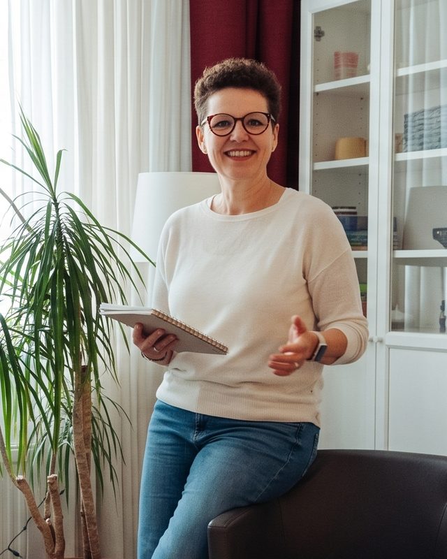 Silke Lemhöfer in ihrer Praxis, lächelnd, mit einem Notizbuch in der Hand